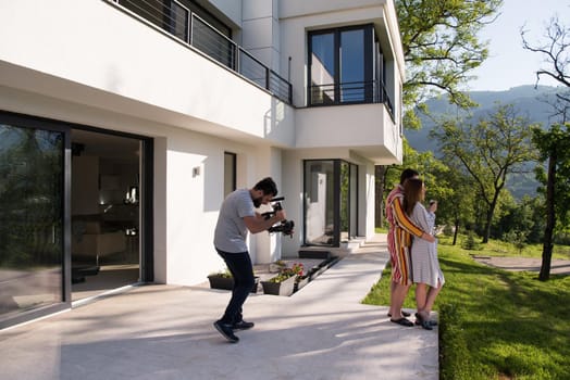 Young beautiful couple in bathrobes are enjoying morning coffee in front of their luxury home villa