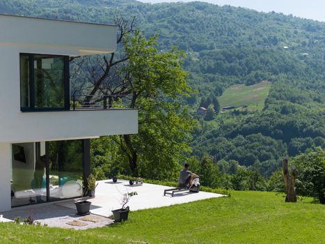 young handsome man doing morning exercises in front of his luxury home villa