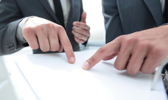 Two pairs of hands passing over business plan