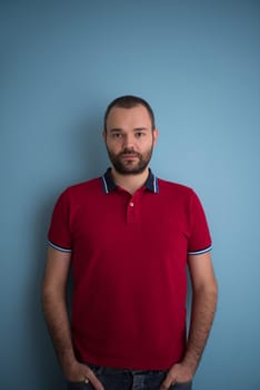 portrait of young man with hands in the pockets isolated over a blue background