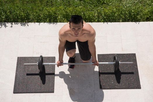 young handsome man doing morning exercises in front of his luxury home villa