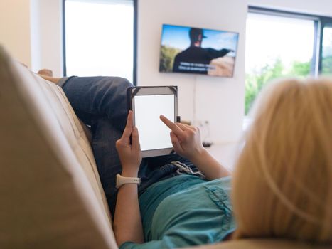 young happy woman on sofa using tablet computer at luxury home