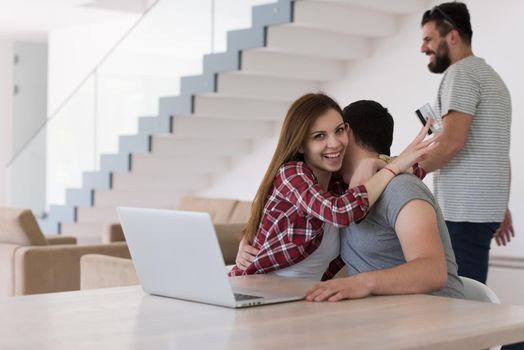 happy young couple buying online using laptop a computer and a credit card in their luxury home villa