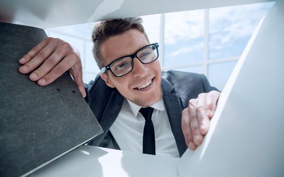 a man in glasses looks at a folder with documents in the office