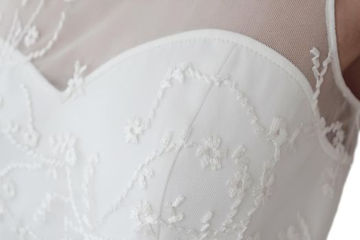 Detail of a wedding dress made of satin and lace. The bodice is transparent without sleeves. A delicate cream shade. Concept: wedding celebration, evening dress salon, luxury atelier, fabric store. High quality photo