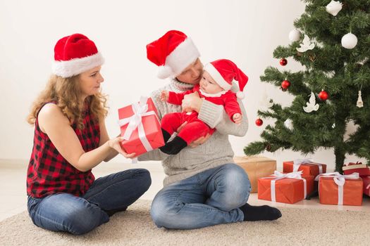 Happy couple with baby celebrating Christmas together at home