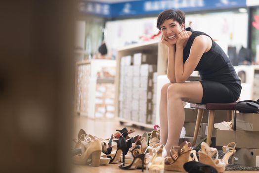 Woman Chooses  Shoes At Fashionable Shop