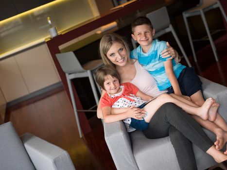 Happy Family Lying Down On The Sofa And Using Tablet