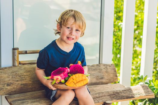 Diced dragon fruit and mango in the hands of the boy.