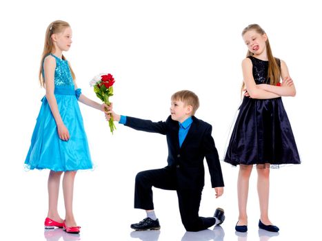 A little boy gives a little girl flowers. The concept of a happy childhood, love. Isolated on white background.