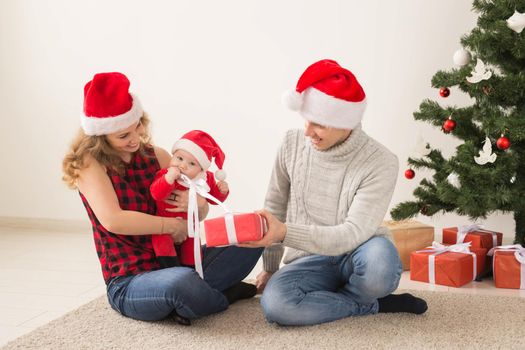 Happy couple with baby celebrating Christmas together at home