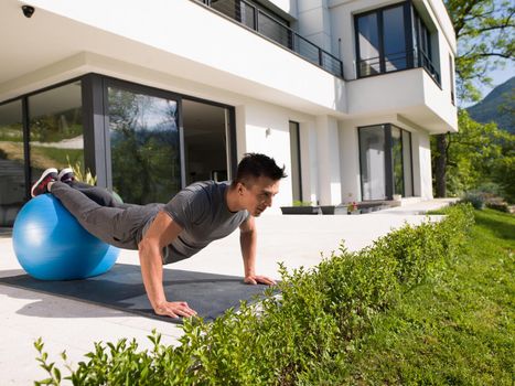 young handsome man doing morning yoga exercises in front of his luxury home villa