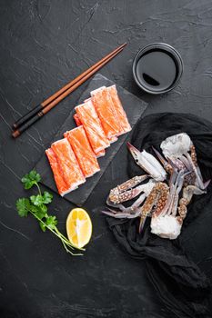 Fresh Crab meat surimi with blue swimming crab set, on stone board, on black background, top view flat lay