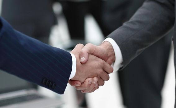 close-up of handshake business partners on blurred background