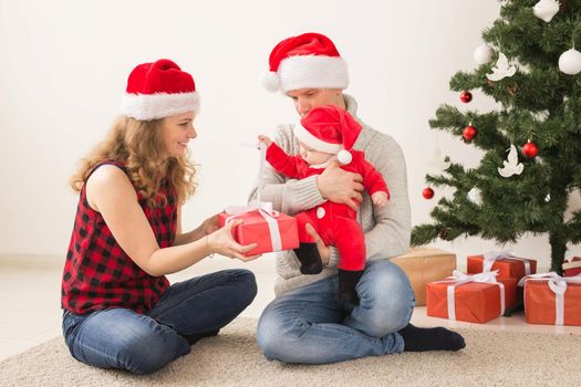 Happy couple with baby celebrating Christmas together at home