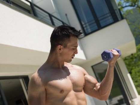 young handsome man doing morning exercises in front of his luxury home villa