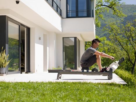 young handsome man doing morning exercises in front of his luxury home villa