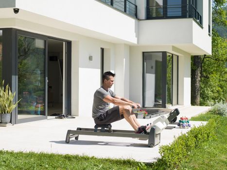 young handsome man doing morning exercises in front of his luxury home villa