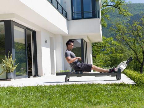 young handsome man doing morning exercises in front of his luxury home villa