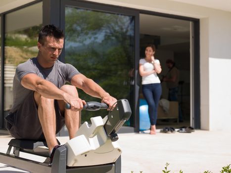 young handsome man doing morning exercises in front of his luxury home villa