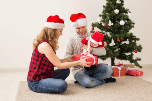 Happy couple with baby celebrating Christmas together at home