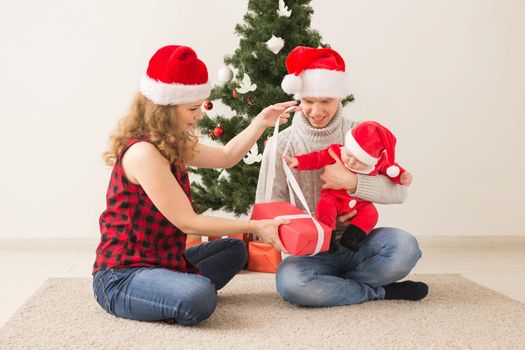 Happy couple with baby celebrating Christmas together at home