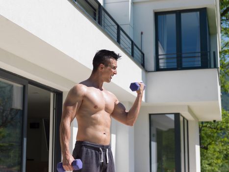 young handsome man doing morning exercises in front of his luxury home villa