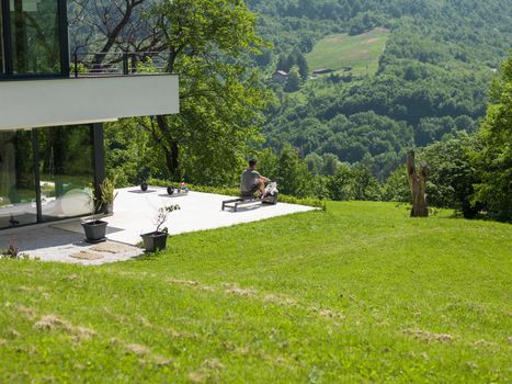 young handsome man doing morning exercises in front of his luxury home villa