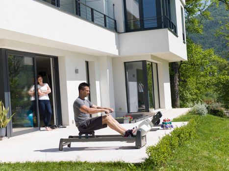 young handsome man doing morning exercises in front of his luxury home villa