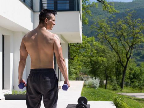 young handsome man doing morning exercises in front of his luxury home villa