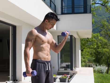 young handsome man doing morning exercises in front of his luxury home villa