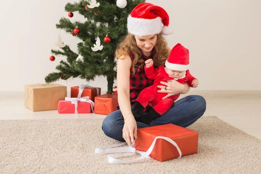 Family, childhood and Christmas concept - Portrait of happy mother and adorable baby in suit of Santa.