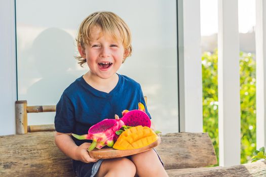 Diced dragon fruit and mango in the hands of the boy.