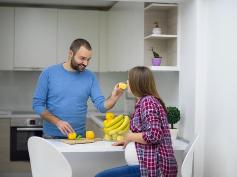 young pregnant couple cooking food fruit lemon juice at kitchen, lifestyle healthy pregnancy happy life concept