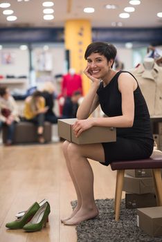 Woman Chooses  Shoes At Fashionable Shop