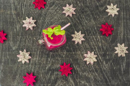 Pieces of sliced dragon fruit in the form of a star and smoothies from a dragon fruit on an old withered background.