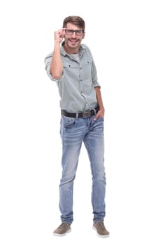 in full growth. a young man looking through his glasses .isolated on white background