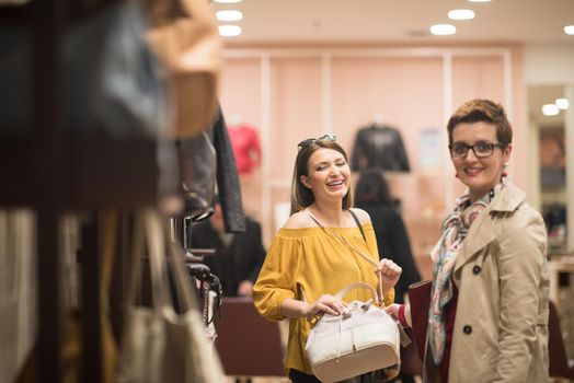 Two Girl-Friends On Shopping Walk On Shopping Centre With Bags And Choosing