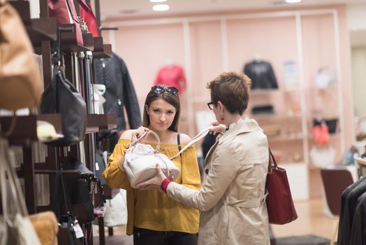 Two Girl-Friends On Shopping Walk On Shopping Centre With Bags And Choosing