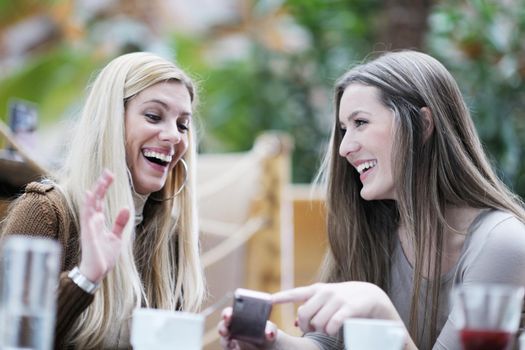 very cute smiling women drinking a coffee sitting inside in cafe restaurant