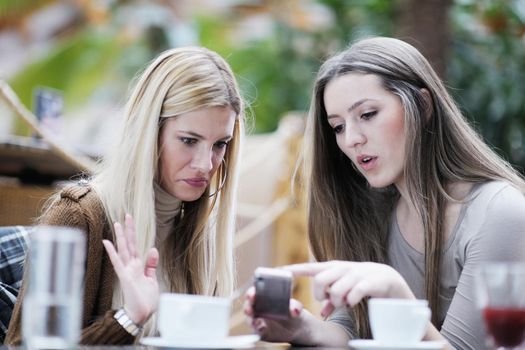 very cute smiling women drinking a coffee sitting inside in cafe restaurant