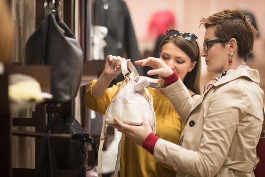 Two Girl-Friends On Shopping Walk On Shopping Centre With Bags And Choosing