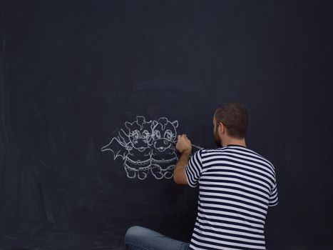 Conceptual photo of future dad drawing his imaginations about the future life with children on chalk board