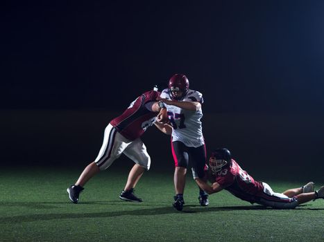 American football players in action at night game time on the field