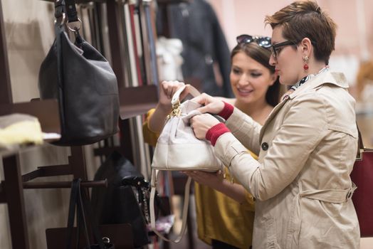 Two Girl-Friends On Shopping Walk On Shopping Centre With Bags And Choosing