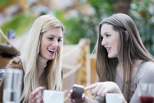 very cute smiling women drinking a coffee sitting inside in cafe restaurant