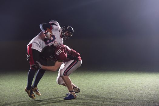 American football players in action at night game time on the field