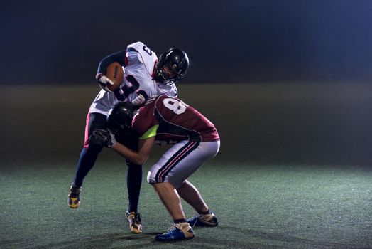 American football players in action at night game time on the field