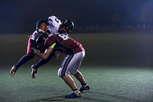 American football players in action at night game time on the field