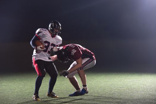 American football players in action at night game time on the field